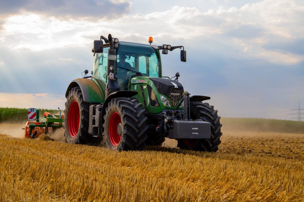 green-tractor-plowing-the-fields-on-focus-photography-2933243 A powerful green tractor plowing a dusty wheat field under a cloudy summer sky in rural Germany.